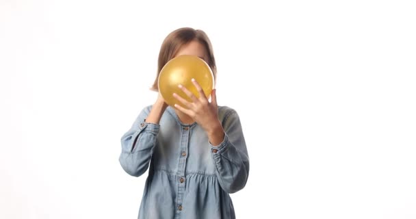 Досить Маленька Дівчинка Повсякденній Джинсовій Сукні Надуває Жовту Кульку Білому — стокове відео