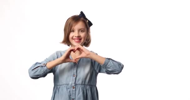Χαμογελαστό Κοριτσάκι Κάνει Σημάδι Της Καρδιάς Χέρια Casual Denim Φόρεμα — Αρχείο Βίντεο