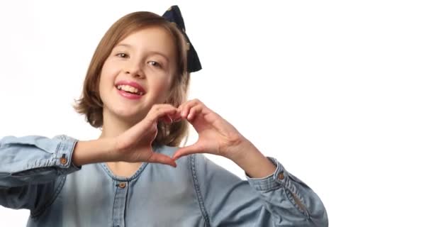 Lächelndes Kleines Mädchen Macht Herzzeichen Mit Händen Lässigem Jeanskleid Isoliert — Stockvideo