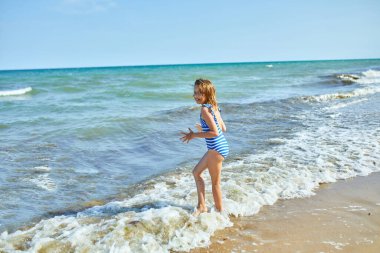 Happy, joyful little girl run on the beach , sea family vacation, Resort fun by the sea