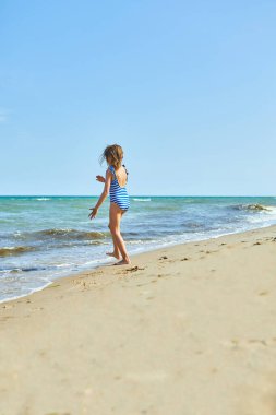 Happy, joyful little girl run on the beach , sea family vacation, Resort fun by the sea