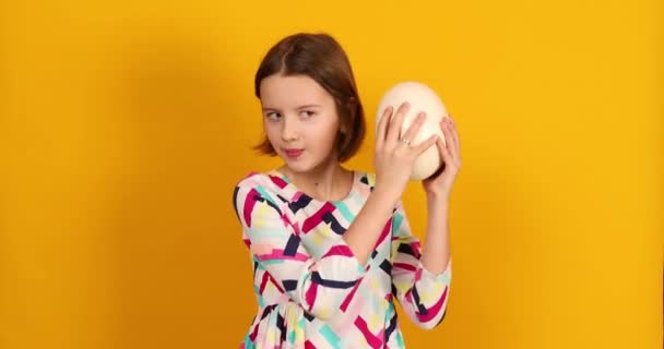 Happy Playful Teenager Girl Holding Ostrich Eggs Bright Yellow Studio — Stockvideo