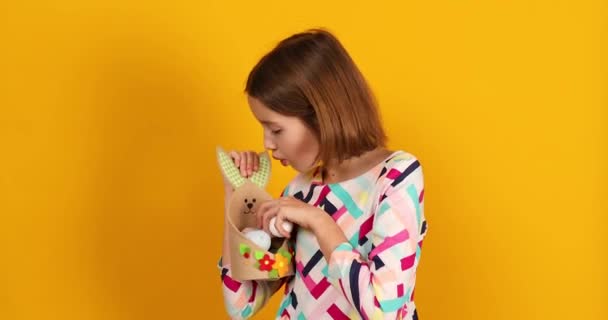 토끼처럼 바구니에 부활절 달걀을칠 노란색 스튜디오 부활절을 축하하는 장난기있는 — 비디오