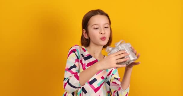 Hoş Çocuk Genç Kız Sarı Arka Planda Gümüş Hediye Kutusunu — Stok video