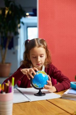 İşyerindeki mutlu kız öğrenci, sınıftaki dünyayı öğreniyor, okula dönüyor, eğitim kavramına dönüyor..