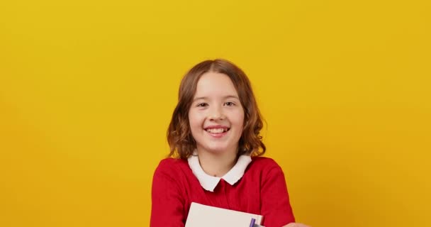 Щаслива Школярка Підліток Тримає Книгу Руці Жовтому Фоні Студії Освітня — стокове відео