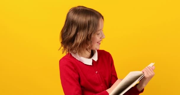 Glückliches Schulmädchen Liest Ein Buch Auf Gelbem Studiohintergrund Educatin Konzept — Stockvideo