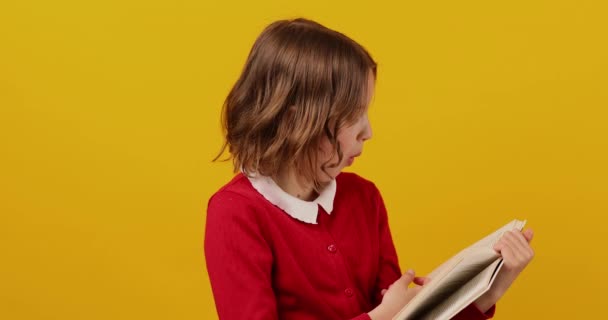 幸せな女子高生読書A本の黄色のスタジオの背景 教育の概念 バックへ学校 コピースペース 十代の女の子の学校の制服 — ストック動画