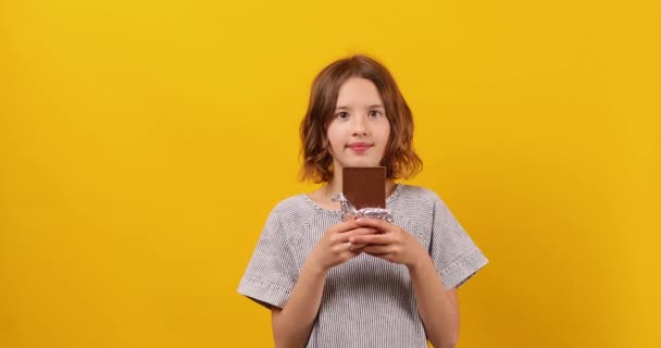 Hezká Teen Dívka Čokoládovou Tyčinkou Izolované Žlutém Pozadí Studia Těší — Stock video