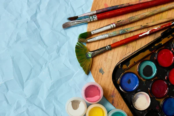 Colocação Plana Tintas Coloridas Paleta Pintura Pincéis Fundo Azul Arte — Fotografia de Stock