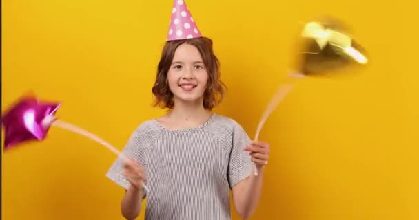 쾌활하고 긍정적 생일을 풍선을 모자를 스튜디오 배경에서 — 비디오