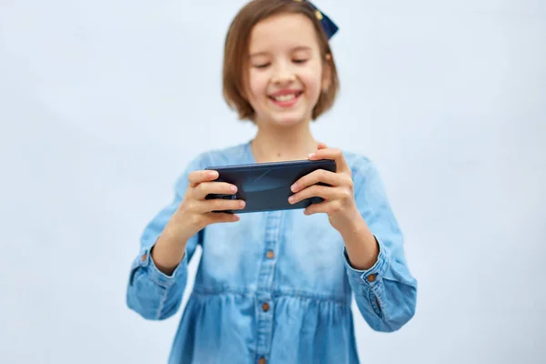 Fun Excited Kid Girl Casual Denim Dress Use Smartphone Enjoys — Zdjęcie stockowe