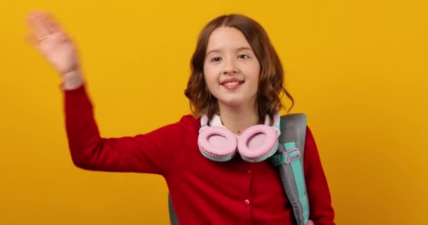 Stílusos Iskolás Tinédzser Lány Fülhallgatóban Hátizsákkal Vállán Integet Barátainak Sárga — Stock videók