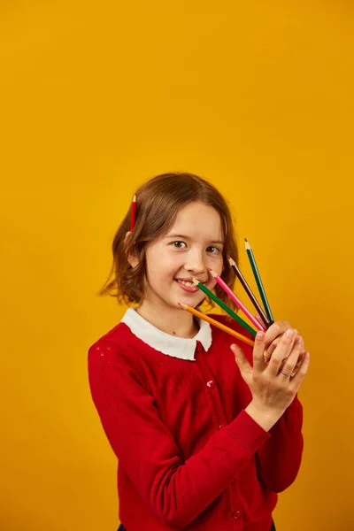用彩色铅笔盖住自己的脸 手牵着黄色的画室背景 回到学校的概念 学习和写作 — 图库照片
