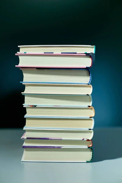 Stack of books on dark backgrounds, World book day, knowledge and creativity concept, spring, summer mood, copy space, top view.