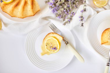 Beyaz masada, lavanta çiçekli bir dilim limonlu kek.