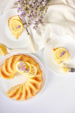 Beyaz masada, lavanta çiçekli bir dilim limonlu kek.