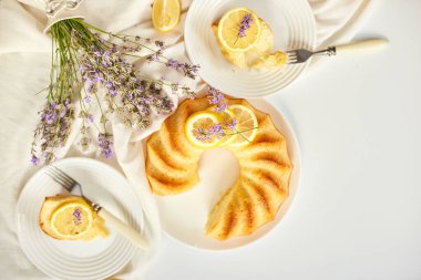 Beyaz masada, lavanta çiçekli bir dilim limonlu kek.