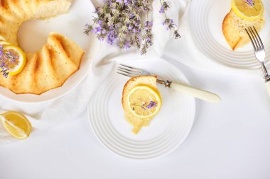 Beyaz masada, lavanta çiçekli bir dilim limonlu kek.