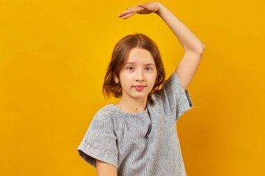 Sarı stüdyoda dans eden mutlu genç kız, pozitif yaşam tarzı konsepti.
