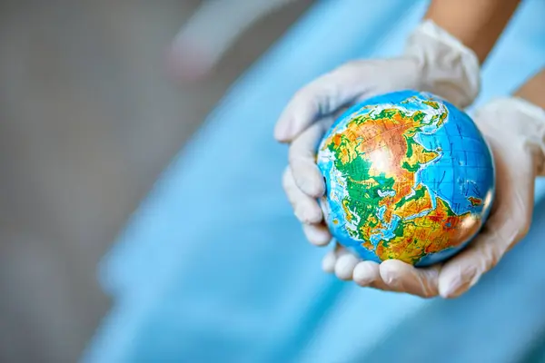 Healthcare worker symbolically cradling the Earth, showcasing care for global health.