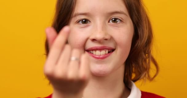 소녀는 노란색 배경에 그녀의 손가락으로 모양을 제스처 비디오 클립