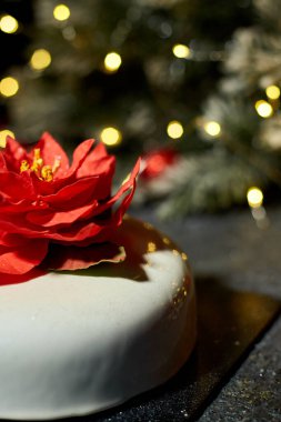 Güzelce hazırlanmış bir tatlı sergisi göz alıcı bir çiçek süslemesi, yanıp sönen ışıklar ve şenlikli yeşilliklerle güçlendirilmiş, davetkar bir tatil atmosferi yaratıyor..