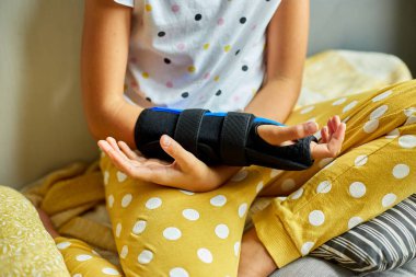 Saç bandı takmış bir kız telli elini yanağında dinlendiriyor, düşünceli görünüyor..