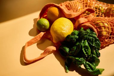 Limon ve limon gibi canlı meyvelerle dolu, yeşil otların yanında sürdürülebilir bir market alışveriş yaklaşımı sergiliyor..