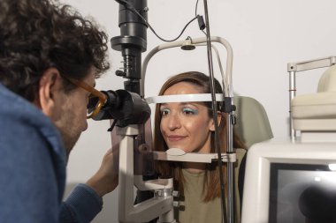 Göz doktoruna examinating genç bir hastaya