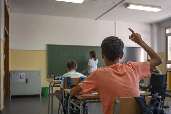 Ένας Έφηβος Σηκώνει Χέρι Του Όπως Γράφει Δάσκαλος Στον Πίνακα — Φωτογραφία Αρχείου