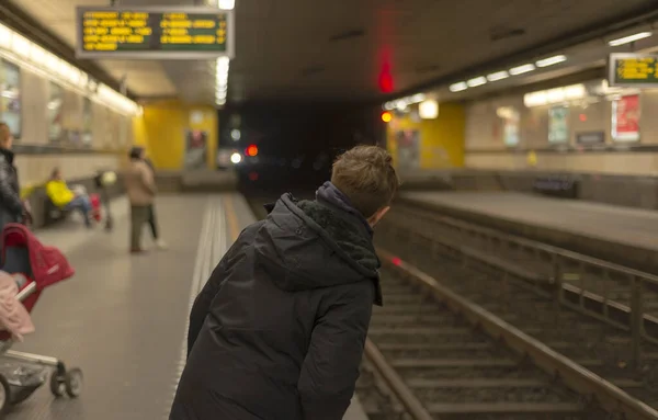 地铁站里的一个少年站在站台上看火车是否到站了 — 图库照片
