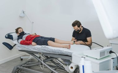 Hastanın ayağında ultrason kullanan bir fizyoterapist. Ayak Fizyoterapisi Konsepti