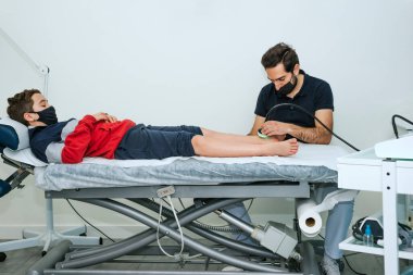 Hastanın ayağında ultrason kullanan bir fizyoterapist. Ayak Fizyoterapisi Konsepti