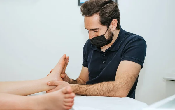 A physiotherapist massages the sole of the foot. Concept Physiotherapy of the foot