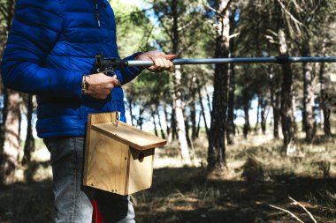 Ağaca asılacak kuş evini hazırlayan bir adamın ellerine yakın çekim..