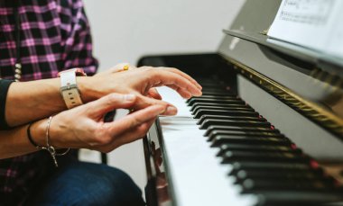 Piyano hocasının ellerini yakın plan çekerek öğrencisinin ellerini...