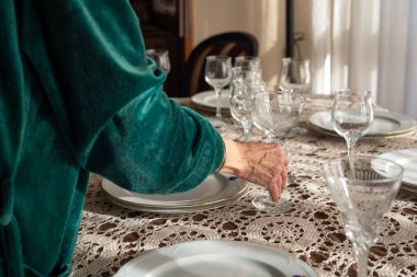 Tanınmayacak kadar yaşlı bir kadın zarif bir Noel yemeği organize ediyor. Evde Noel yemeği için sofrayı hazırlayan kadınların fotoğraflarını kapat..