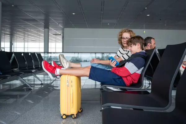 Boy His Mother Engaging Smartphones While Waiting Airport Stock Image