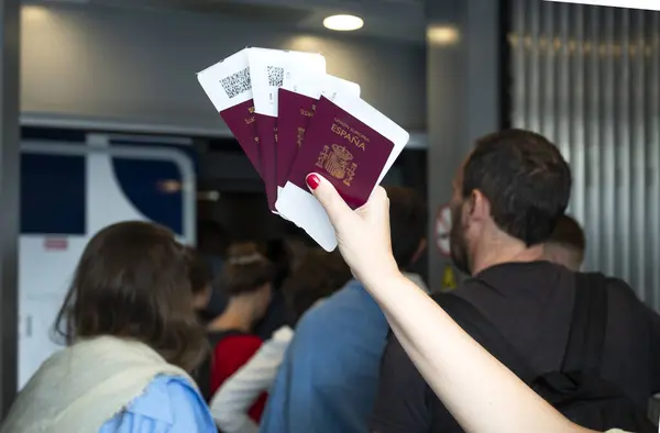 Close Hand Holding Spanish Passports Boarding Passes Passengers Queueing Background Stock Picture