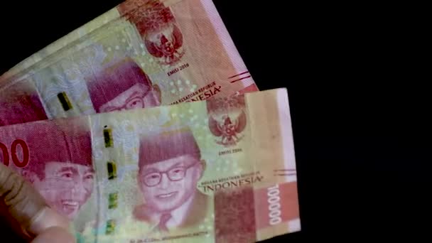 在黑色背景上手工计算10万卢比 印度尼西亚货币 在印度尼西亚的支付方式 — 图库视频影像
