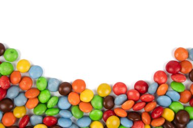 Beyaz arka planda izole edilmiş renkli çikolata şekerleri yığını