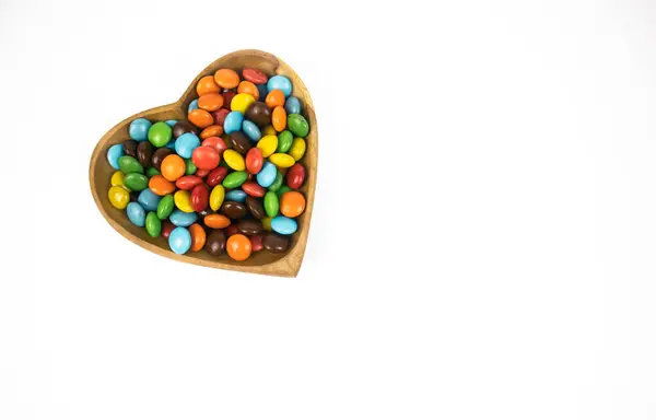 Haufen Bunter Schokoladenbonbons Herzförmiger Holzschale Isoliert Auf Weißem Hintergrund Ansicht — Stockfoto