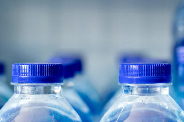 Mineral water bottles in a row with blue caps