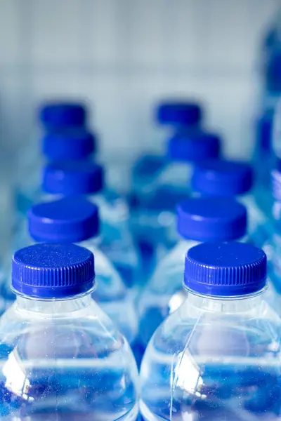 Mineral water bottles in a row with blue caps