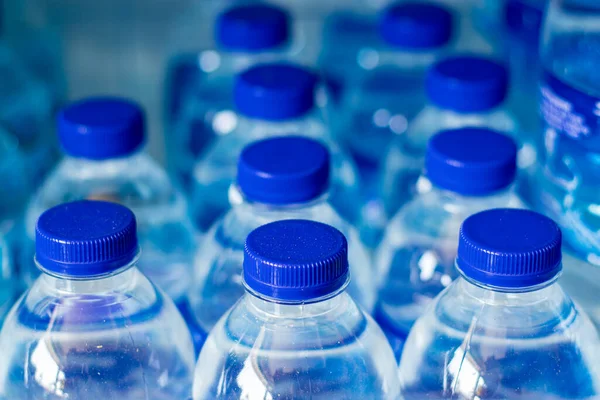 Бутылки Минеральной Водой Ряд Голубыми Колпачками Стоковое Изображение