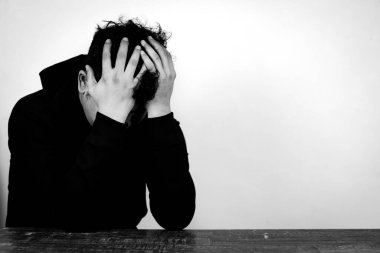 Depresyondaki Asyalı adamın portresi yüzünü beyaz ve siyah arka planda gizliyor.