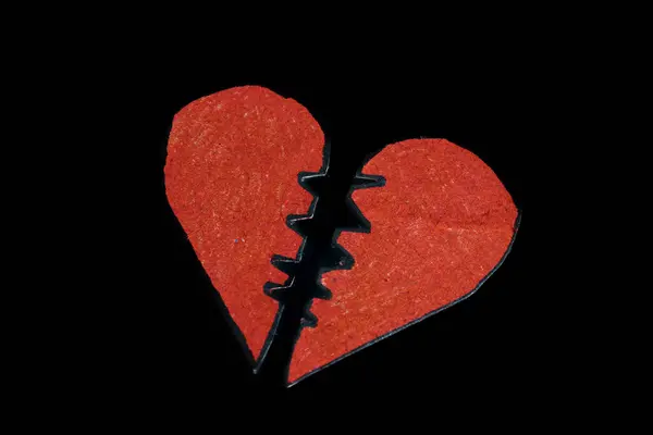 Red broken heart on dark background