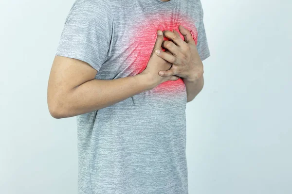 asian man pressing chest with painful expression. Severe heartache, having a heart attack or painful cramps, heart disease.