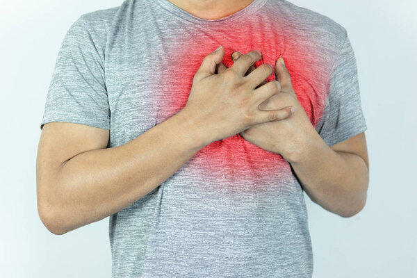 asian man pressing chest with painful expression. Severe heartache, having a heart attack or painful cramps, heart disease.